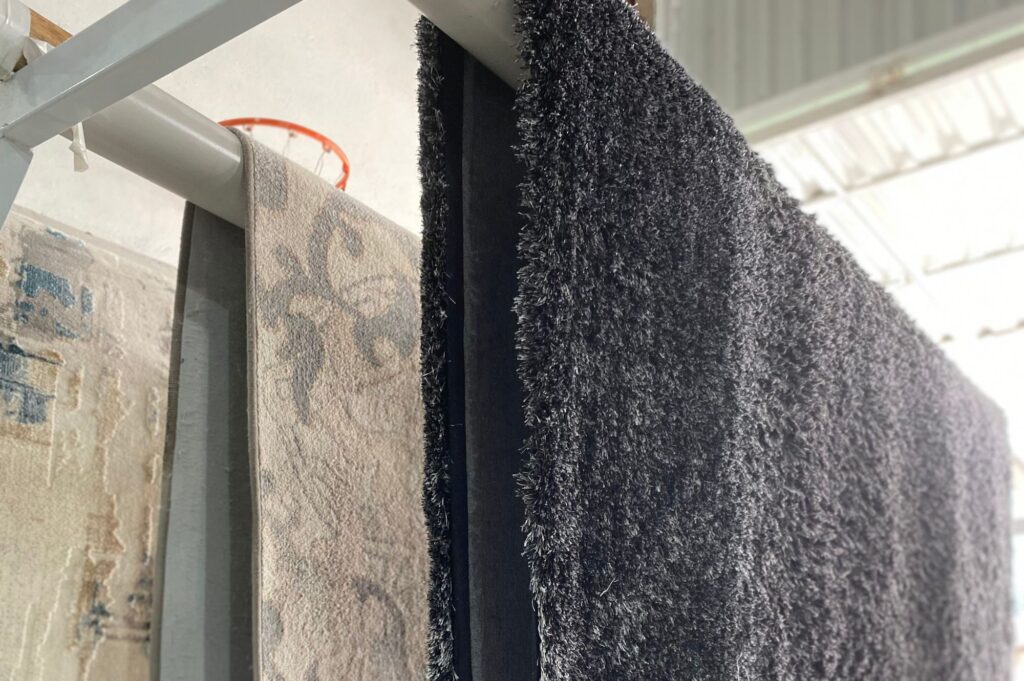 Tapetes secando em uma lavanderia de tapetes especializada, exibindo o cuidado e os processos adequados para preservar sua qualidade durante o processo de secagem.