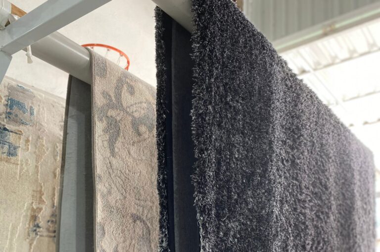 Tapetes secando em uma lavanderia de tapetes especializada, exibindo o cuidado e os processos adequados para preservar sua qualidade durante o processo de secagem.